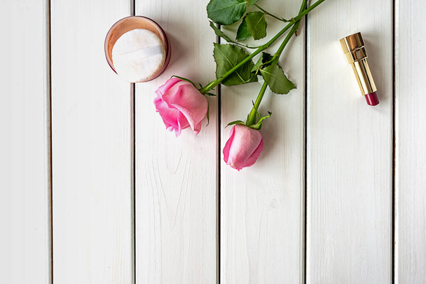 Σύνθεση με make-up, τριαντάφυλλα και φωτοτυπίες σε λευκό ξύλινο φόντο - Φωτογραφία, εικόνα