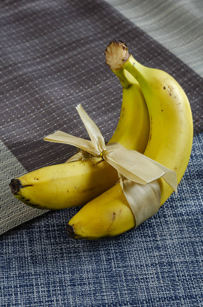 Kaksi banaania nauhalla, varastossa kuva. Kypsiä banaaneja monivärinen tausta. Rakkaus, suhde, häät käsite. - Valokuva, kuva