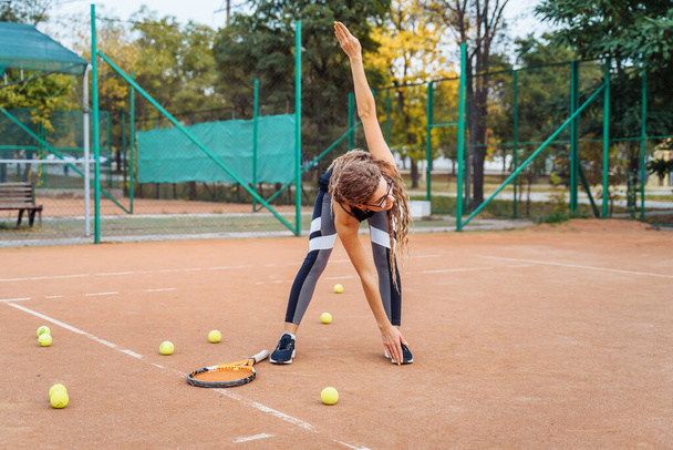 Qualitative warm-up. Warming up your muscles before an intense tennis workout on the court. Preparatory steps for an important tennis match. Sports exercises to help tone muscles. - Photo, Image