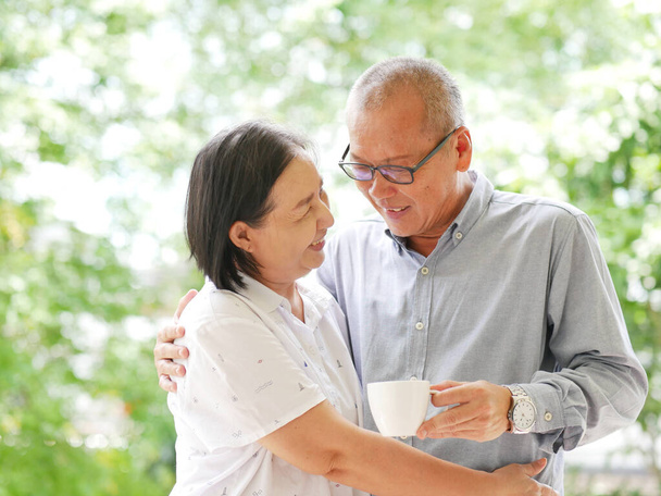 Primer plano Retrato asia feliz pareja de ancianos hablando y beber café en el jardín. - Foto, Imagen