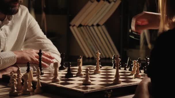 Genç adam ve kadın kapalı alanda satranç oynuyorlar. - Video, Çekim