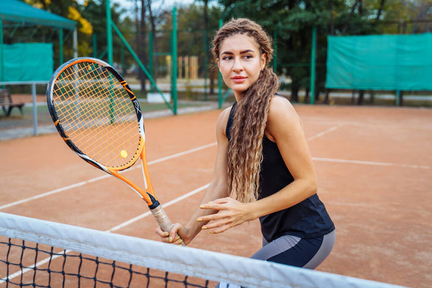 Confident handling of the ball when playing on the net. An attractive, beautiful tennis player practicing exercises to improve her skill level. Games in motion, action. Favorite sport - tennis. - Photo, Image