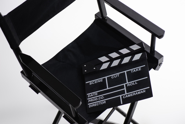 high angle view of clapperboard on director chair on white, cinema concept - Photo, Image