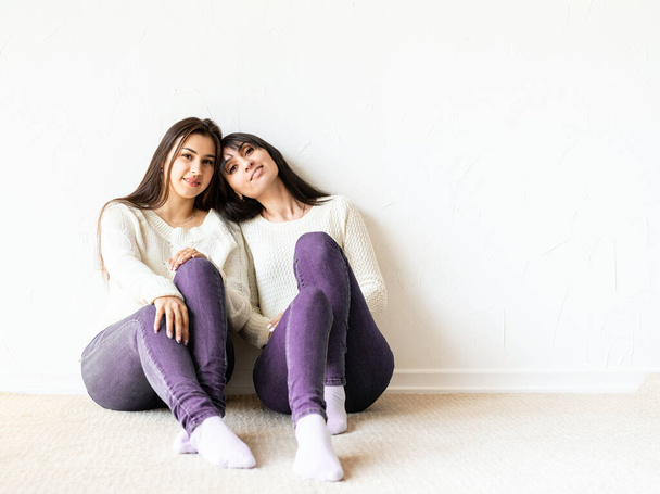 Zwei beste Freundinnen in lässiger Kleidung sitzen zu Hause zusammen. Kopierraum - Foto, Bild