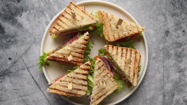 Вкусный и свежий клубный сэндвич подается на белой керамической тарелке - Кадры, видео
