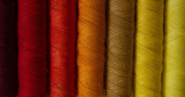 Spools of red and yellow thread in shade order. Macro close up - Fotó, kép