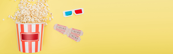 Ansicht von 3D-Gläsern, Kinokarten und Eimer mit Popcorn auf gelb, Banner - Foto, Bild