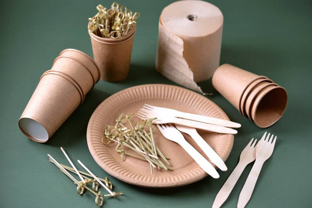 Jednorázové biologicky rozložitelné stolní nádobí na řemeslném papíru - vidličky, sklenice a talíře. Nulový plýtvání. Horní pohled.  - Fotografie, Obrázek