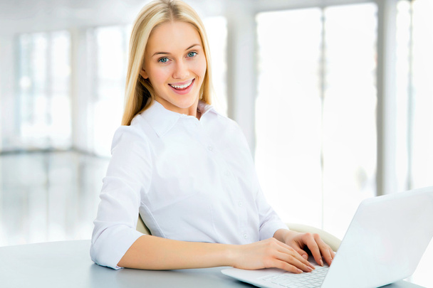 Smiling businesswoman using laptop - Fotó, kép