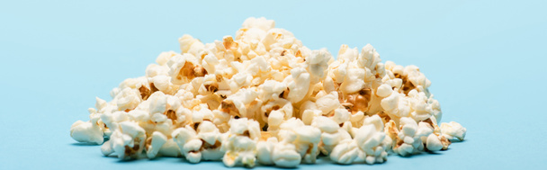 stapel smakelijke zoute popcorn op blauw, banner, bioscoop concept - Foto, afbeelding