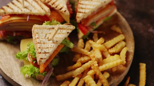 Club sandwiches served on a wooden board. With hot French fries - Footage, Video