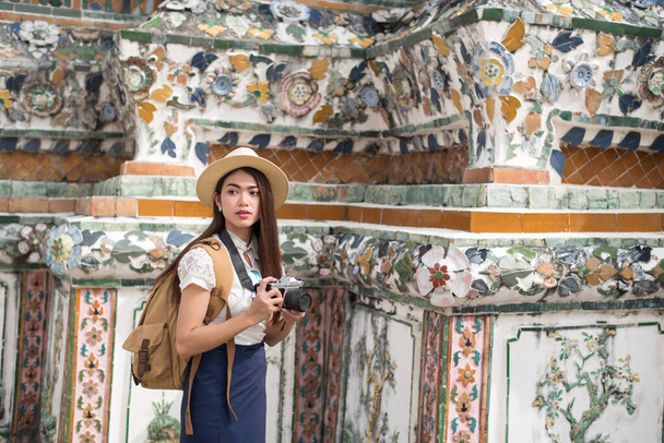 Jonge Aziatische toeristen reizen bij Wat Arun Ratchawararam (de tempel van de dageraad), een van de beroemde plaatsen in Bangkok, Thailand - Foto, afbeelding