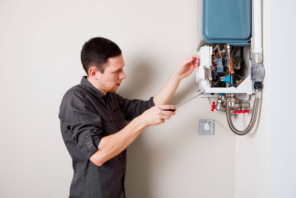 Plumber attaches Trying To Fix the Problem with the Residential Heating Equipment. Repair of a gas boiler - Foto, Imagem