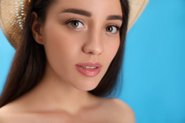 Portrait of beautiful young woman on light blue background, closeup - Фото, изображение