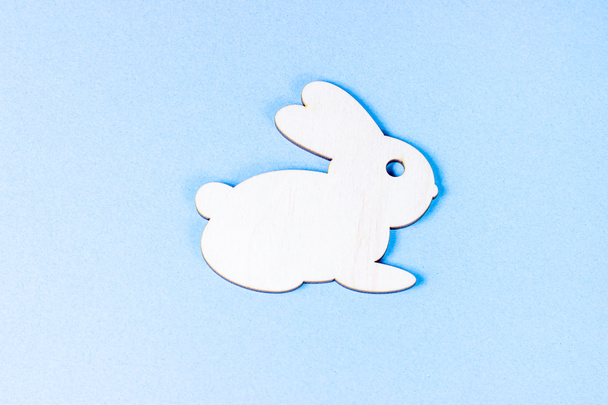 Vista superior plana poner divertido conejo de Pascua de madera con huevos de colores como símbolos de una fiesta con espacio de copia sobre fondo rosa claro. - Foto, Imagen
