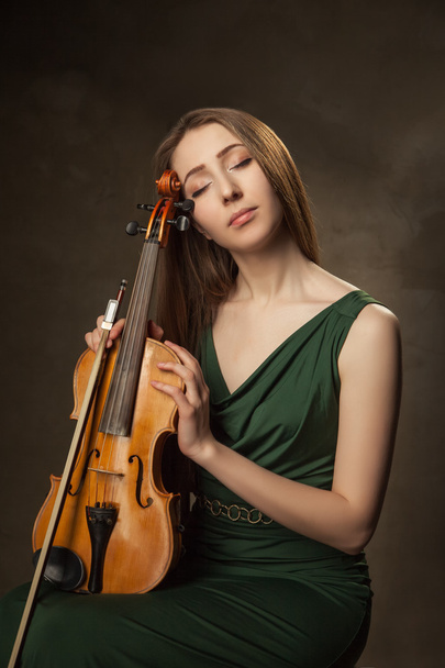 Beautiful young woman playing violin over black - Φωτογραφία, εικόνα