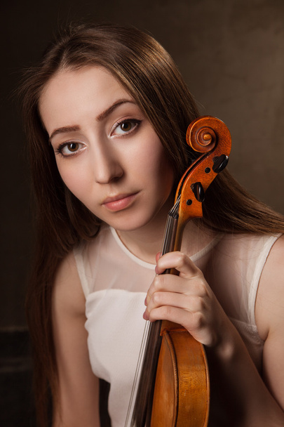 Beautiful young woman playing violin over black - Foto, afbeelding