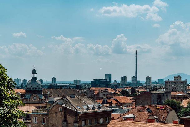Panoramatický výhled na Záhřeb, Chorvatsko z Horního Města se starobylými budovami, socialistickými obytnými bloky a průmyslovým komínem - Fotografie, Obrázek