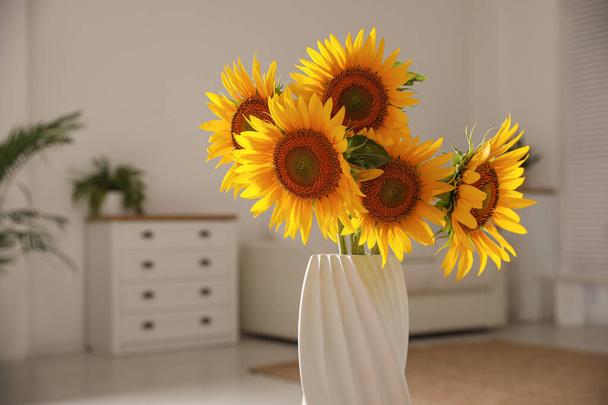 Beautiful bouquet of sunflowers in vase at home, closeup - 写真・画像