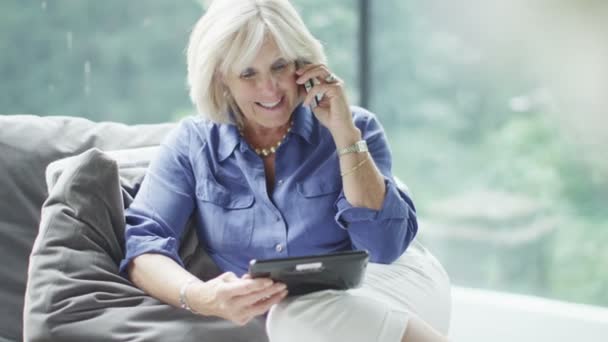 Mature woman making  phone call with tablet - Filmmaterial, Video