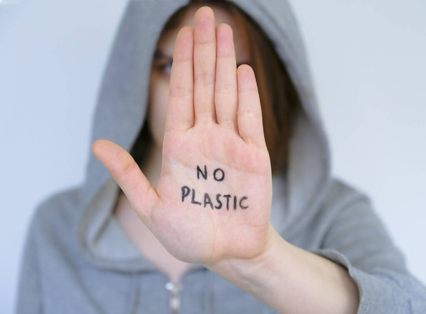 Say NO to plastic products. Concept. The man says no to the plastic bottle. No waste. Environment. On the palm it says to decline the offer of plastic products - Fotoğraf, Görsel