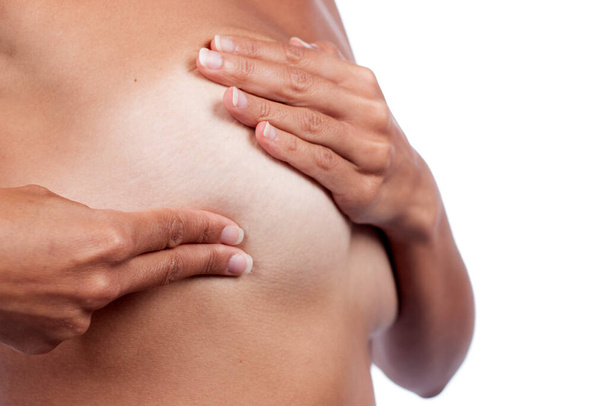 Giovane donna che controlla il seno (auto auto esame) per anomalie, nodi o grumi strani per il cancro al seno. - Foto, immagini