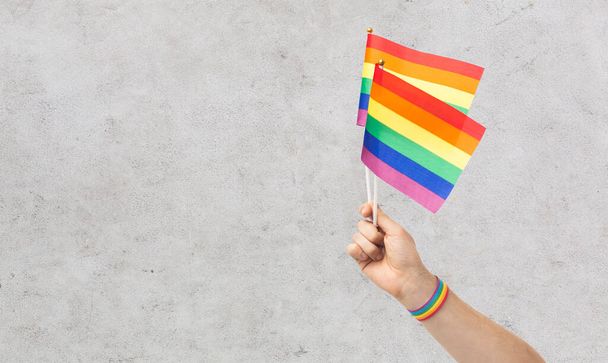 hand with gay pride rainbow flags and wristband - 写真・画像