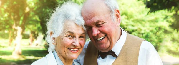 Szczęśliwej historii miłosnej pary. Starsza para spaceruje po zielonym parku. Babcia i dziadek się śmieją. Styl życia osób starszych. - Zdjęcie, obraz