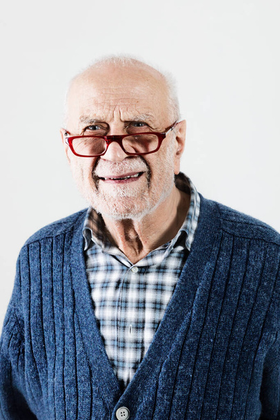 Senior gentleman in the studio on a white background, blue sweater - 写真・画像