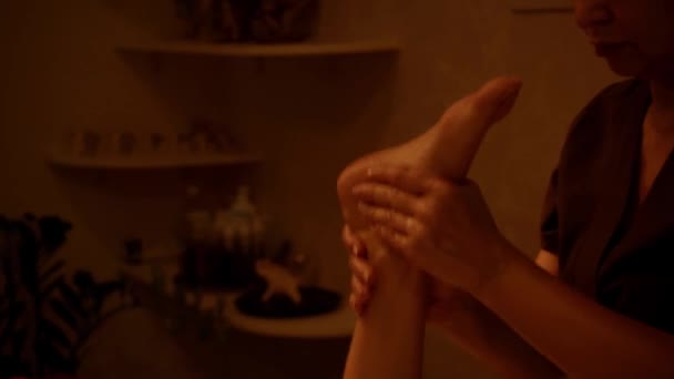 vue recadrée de masseur professionnel massant pieds nus jambe du client - Séquence, vidéo