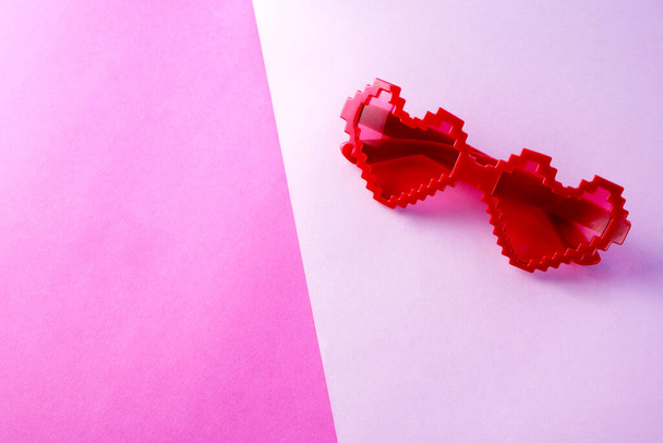 Gafas rosadas en forma de corazón sobre fondo rosa. Día de San Valentín. - Foto, imagen