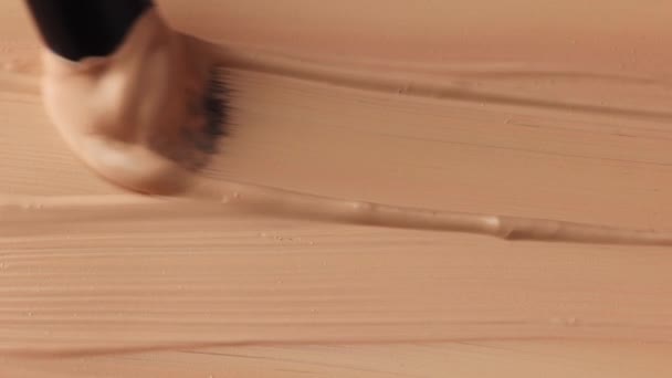 beige Abstrich der tonal Foundation Creme Hintergrund Nahaufnahme, wischen mit einem Pinsel, schöne Pastell-Textur, Kosmetikprodukt für Make-up - Filmmaterial, Video