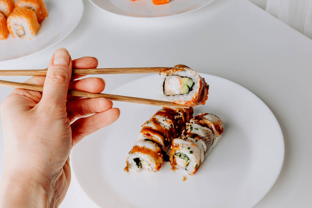 Japanese food: maki and nigiri sushi set. Sushi rolls (Philadelphia) with rice, fish salmon, smoked eel, avocado, cream cheese, soy Teriyaki sauce, sesame. Chopsticks, wasabi and Pickled Ginger. - Fotoğraf, Görsel