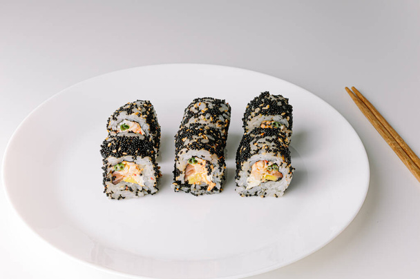 Japanese food: maki and nigiri sushi set. Sushi rolls (Philadelphia) with rice, fish salmon, smoked eel, avocado, cream cheese, soy Teriyaki sauce, sesame. Chopsticks, wasabi and Pickled Ginger. - Zdjęcie, obraz