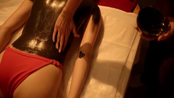 αισθητικός εφαρμογή καλλυντική λάσπη στο σώμα του πελάτη σε spa σαλόνι - Πλάνα, βίντεο