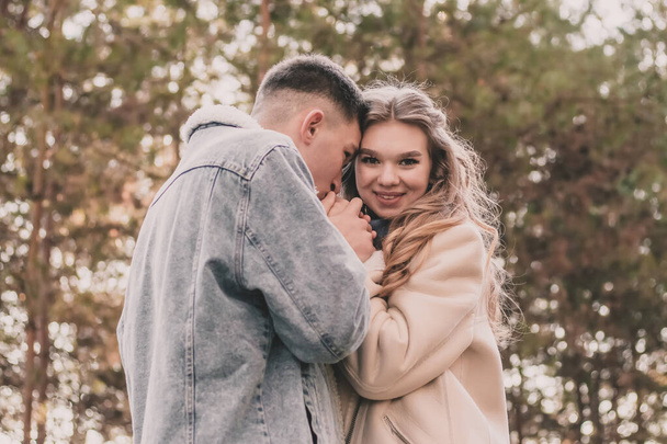 男は少女の手を握ってキスをし少女は笑顔で冬の松林の中で - 写真・画像