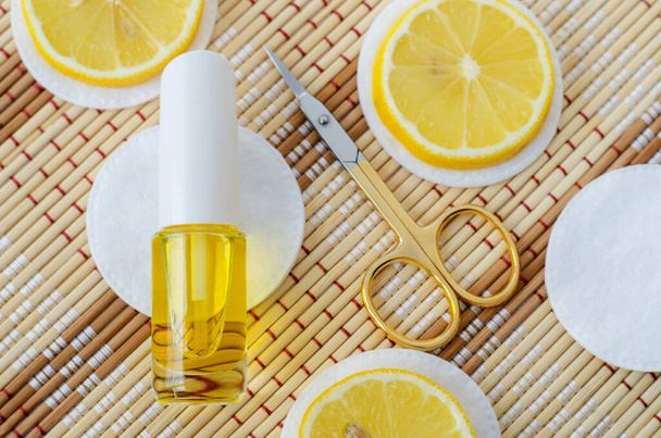 Kis palack esszenciális citromolajjal (kivonat, tinktúra, infúzió, parfüm) és ollóval. Aromaterápia, természetes manikűr és spa. Fénymásolási hely  - Fotó, kép