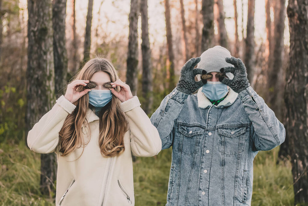 Ein Mann und ein Mädchen in medizinischen Masken in einem Kiefernwald - Foto, Bild