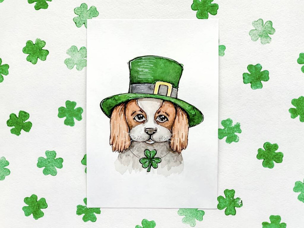 акварельный эскиз: щенок в зеленой ирландской шапке, лист трилистника. Картина святого Патрика Дэя. - Фото, изображение