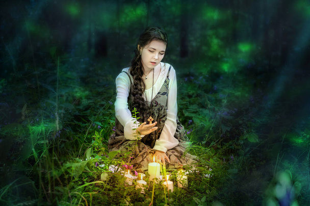 Chica de noche en el bosque realiza un misterioso ritual con velas. - Foto, imagen