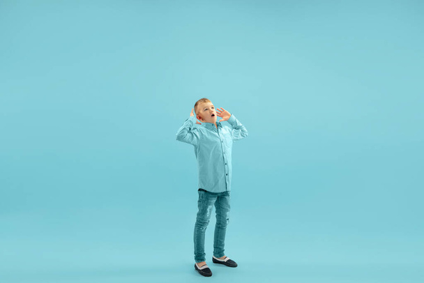 Childhood and dream about big and famous future. Pretty little boy isolated on blue background - Фото, изображение