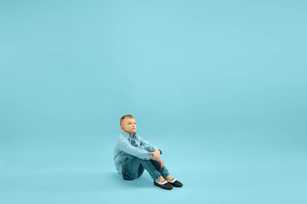 Childhood and dream about big and famous future. Pretty little boy isolated on blue background - Foto, Imagem