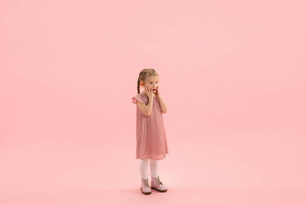 Childhood and dream about big and famous future. Pretty longhair girl isolated on coral pink background - Zdjęcie, obraz