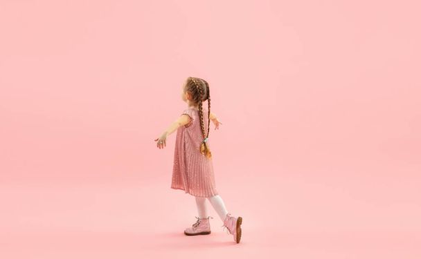Childhood and dream about big and famous future. Pretty longhair girl isolated on coral pink background - Foto, Bild