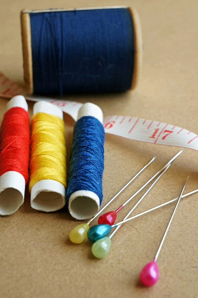Articoli da cucire: bottoni, tessuti colorati, forbici, nastro di misura, ditale, bobine di filo sul modello di cucito
 - Foto, immagini