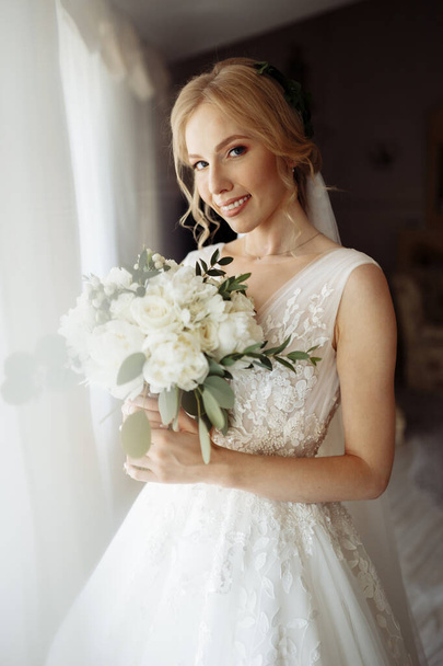 Krásná nevěsta portrét ve svatebních šatech v blízkosti okna - Fotografie, Obrázek