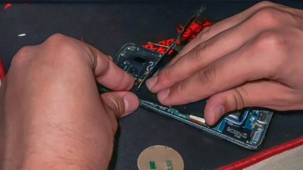 Κοντινό πλάνο των χεριών επισκευή smartphone με εργαλεία σε ένα γραφείο - Φωτογραφία, εικόνα