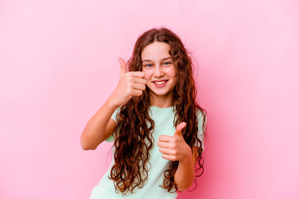 Menina caucasiana pouco isolado no fundo rosa levantando ambos os polegares para cima, sorrindo e confiante. - Foto, Imagem