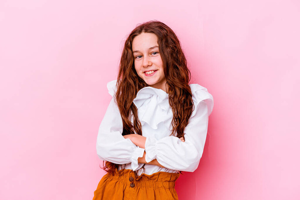 Little caucasian girl isolated on pink background who feels confident, crossing arms with determination. - Photo, Image
