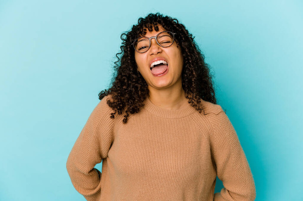 Fiatal afro-amerikai afro nő elszigetelt vicces és barátságos kilóg nyelv. - Fotó, kép